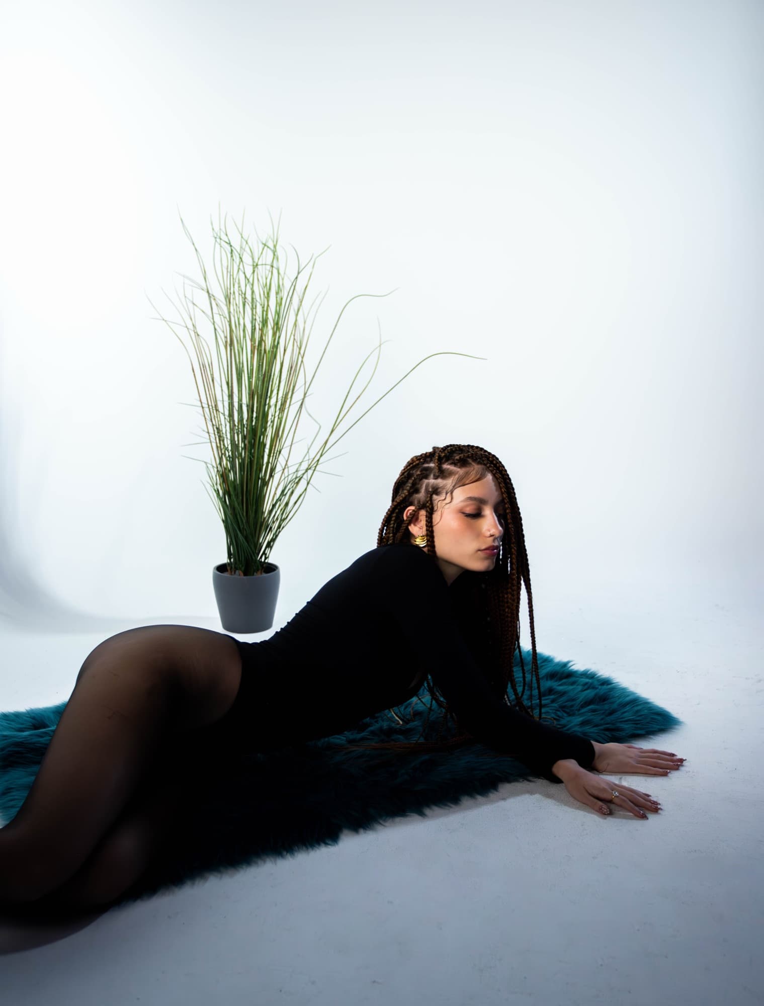 Studio pose on the floor beside a potted plant