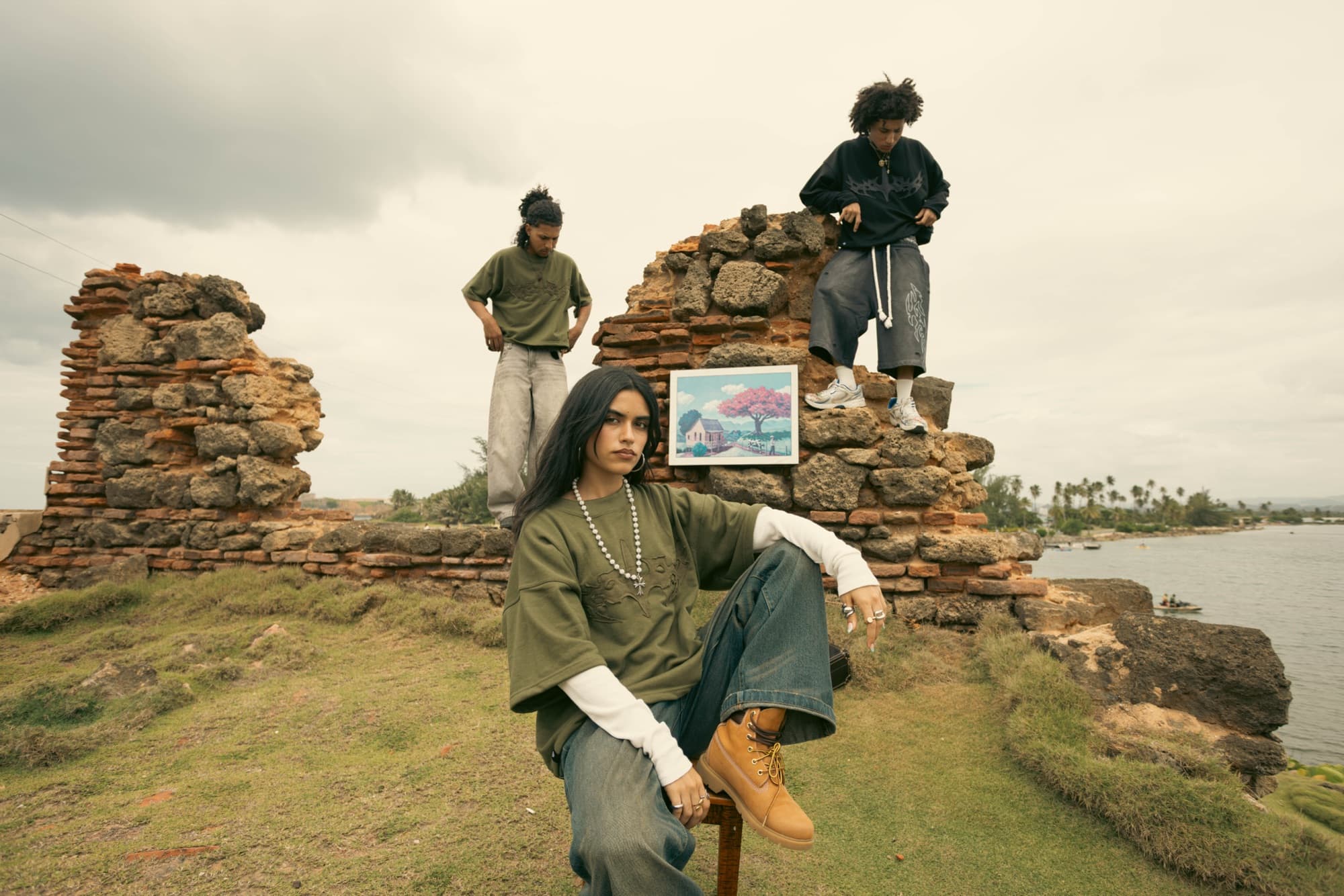 Crew posing on the ruins with a framed print of the coast